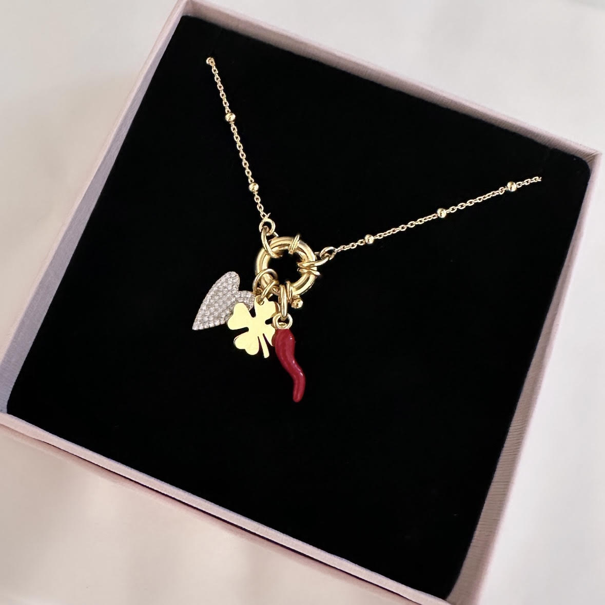 collana in argento 925 placcato oro giallo con ciondoli cuore pavé di zirconi, quadrifoglio e cornetto portafortuna smaltato rosso